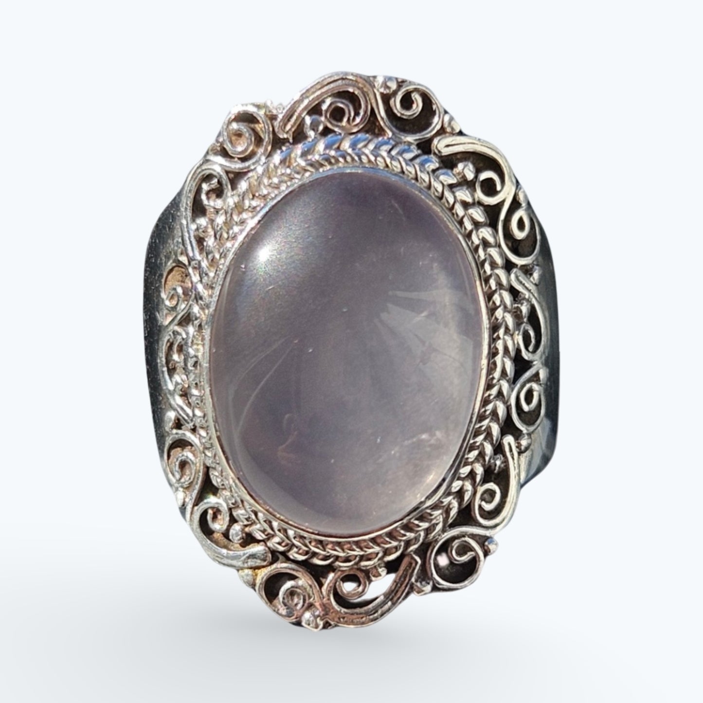 A silver filigree ring featuring a large oval Rose Quartz